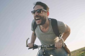 Man laughing while riding his bike
