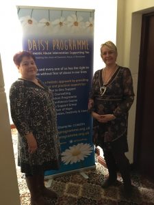 workers from the daisy programme stand with their banner