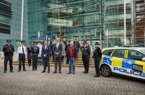 group photo outside Endeavour House, of Suffolk County and other partner agencies standing together for White Ribbon Day after signing the pledge